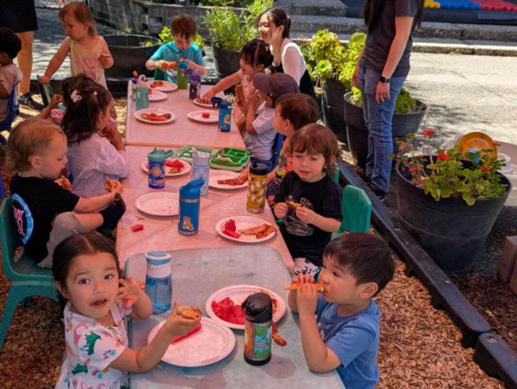 Children eating lunch together at the outdoor table