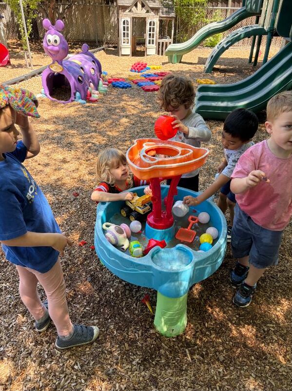 Children playing together at the outdoor water table