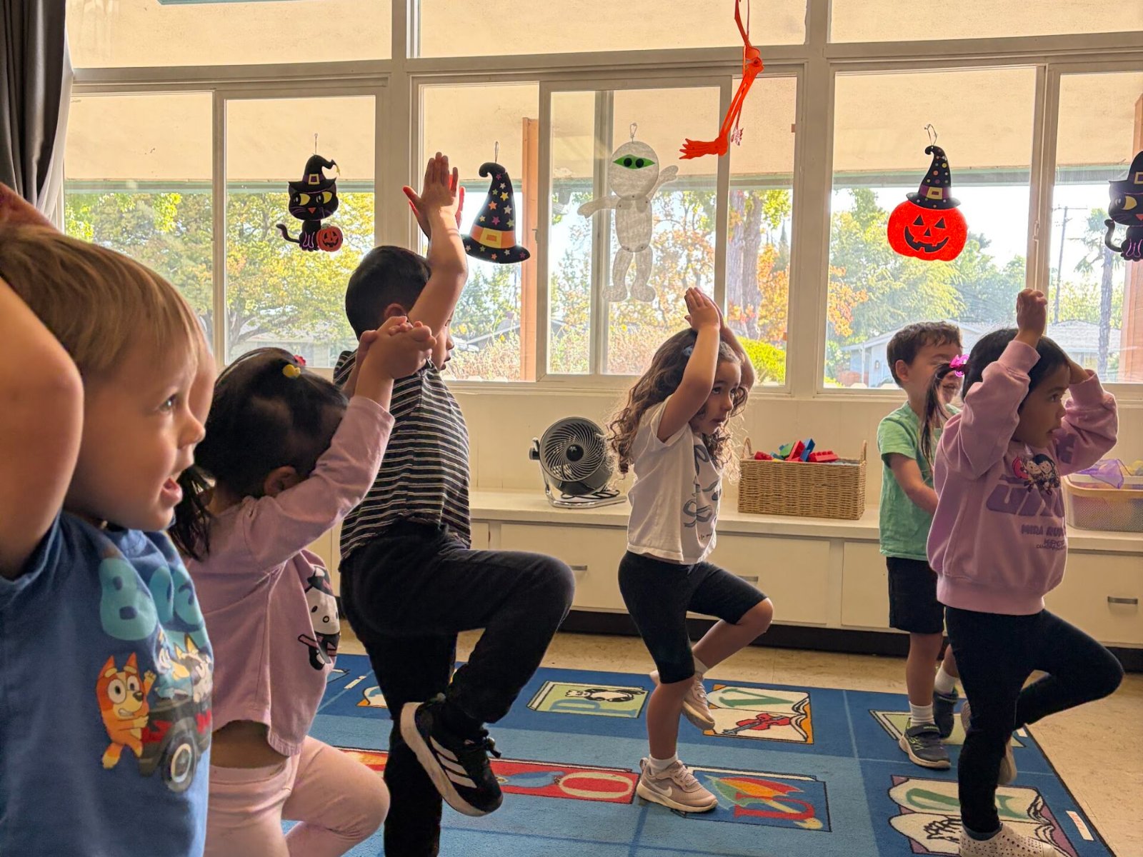 Children holding a yoga pose together in the classroom