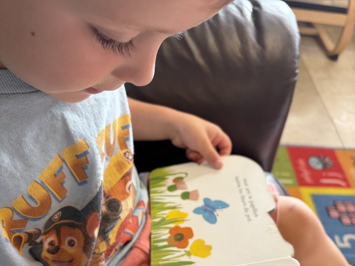 Child reading a French picture book at ECLA