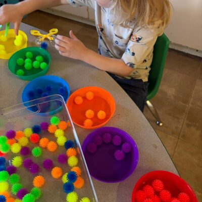 A child sorting pompoms by color