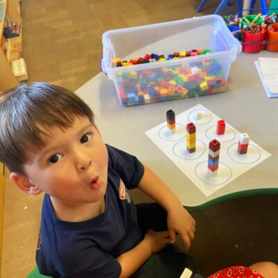 A child working on a counting activity at the table