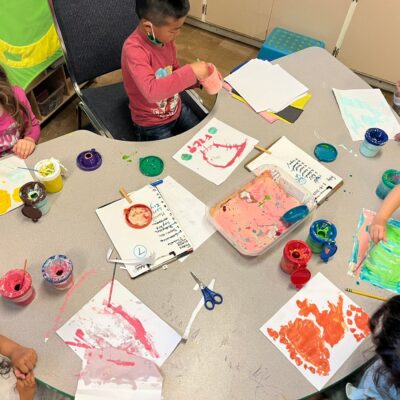 Children painting together at the table