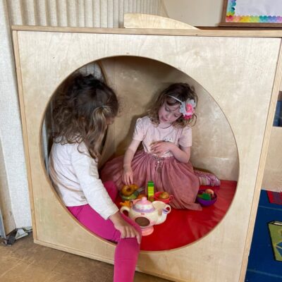 Children having a pretend tea party in the cozy nook