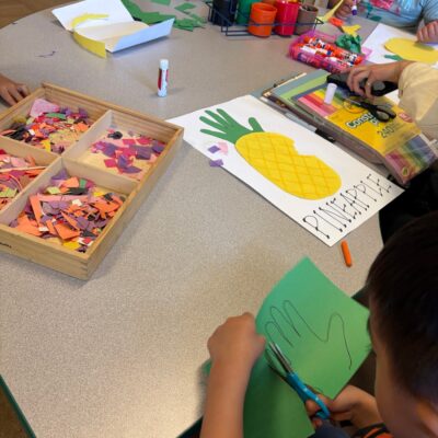 Children cutting and gluing paper crafts at the table
