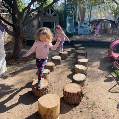 A child balancing along the log stepping path