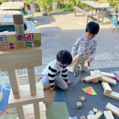 Children building with wooden blocks outdoors