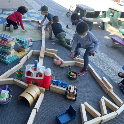 Children building roadways with wooden blocks outdoors